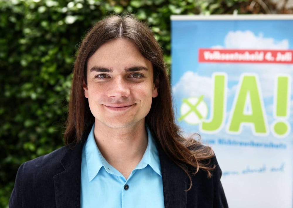 Sebastian Frankenberger vor einem Plakat zum Volksentscheid 2010